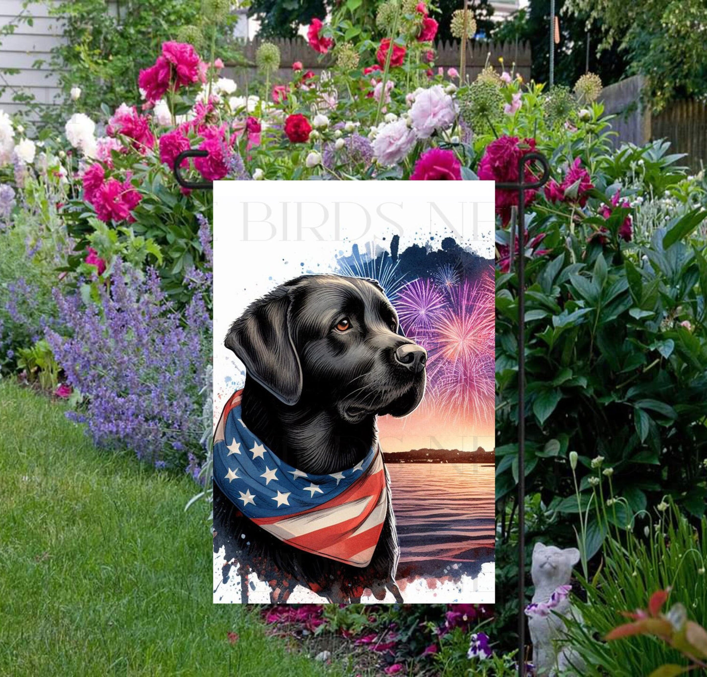 An adorable black Labrador Retriever Dog wearing an American Flag Bandanna on a Beach with Fireworks in the background.