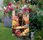 A beautiful Chocolate Labrador Retriever in a wooden cart full of Spring flowers.