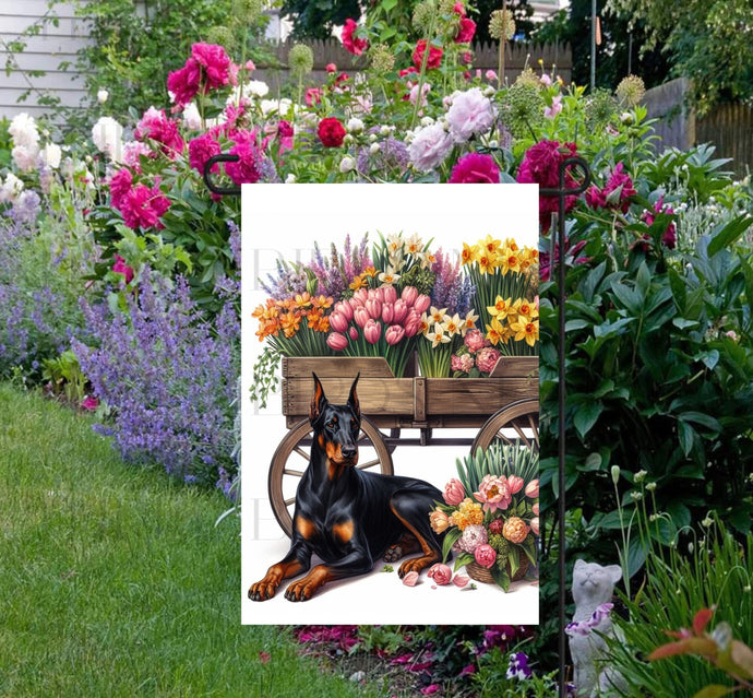 A beautiful black Doberman Pinscher dog surrounded by gorgeous flowers.