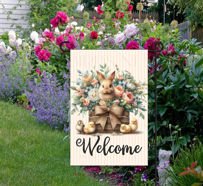 An adorable Easter Bunny Rabbit in a basket of flowers with baby chicks