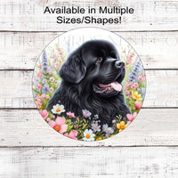 A black Newfoundland dog surrounded by beautiful Spring flowers