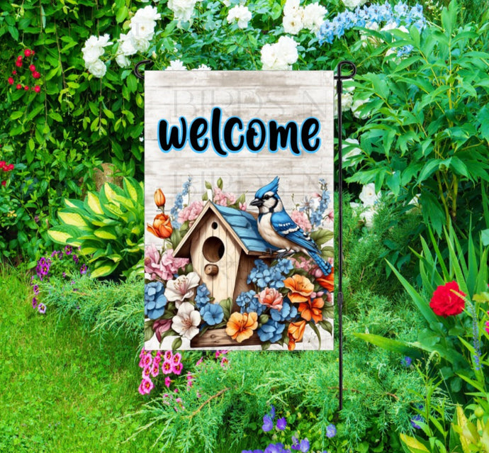 A beautiful Garden Flag with a Blue Jay bird and a birdhouse surrounded by Spring flowers.