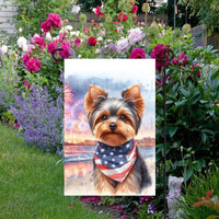 An adorable Yorkshire Terrier Dog wearing an American Flag Bandanna on a Beach with Fireworks in the background.