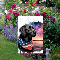 An adorable black Labrador Retriever Dog wearing an American Flag Bandanna on a Beach with Fireworks in the background.