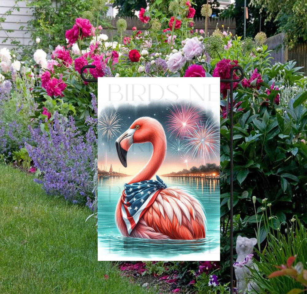 An adorable pink Flamingo wearing an American Flag Bandanna on a Beach with Fireworks in the background.