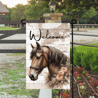 A beautiful brown horse with a collar of greenery and peach flowers on a rustic wood background.