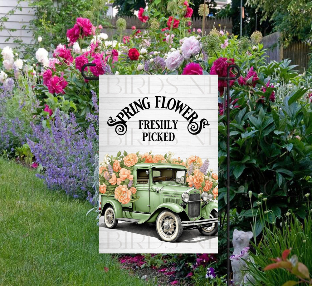 A beautiful green vintage old truck full of Spring flowers.