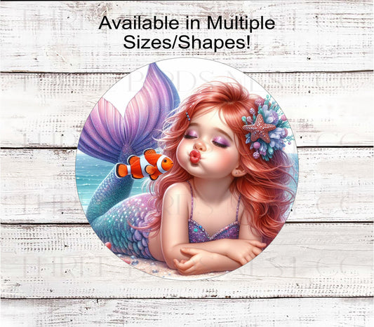A beautiful Beach Wreath Sign featuring a baby girl Mermaid and her Clownfish friend.