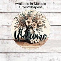 A beautiful rustic metal milk can filled with Magnolia flowers and other flowers and greenery with a Welcome message.