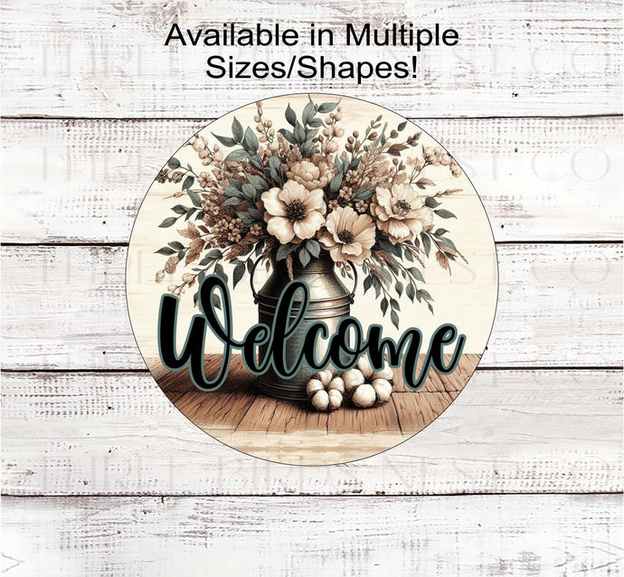 A beautiful rustic metal milk can filled with Magnolia flowers and other flowers and greenery with a Welcome message.