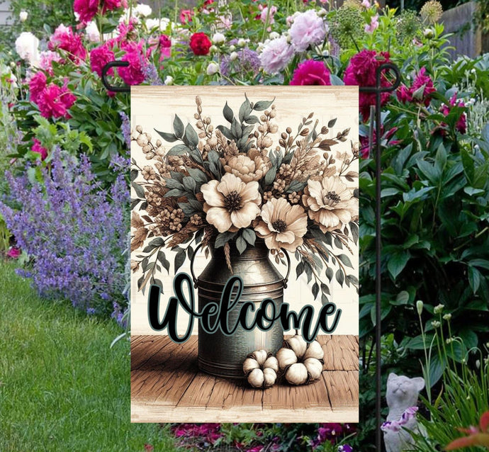 This beautiful double-sided Garden Flag features a rustic farmhouse scene with a metal milk can full of Magnolias, cotton bolls and other flowers with a Welcome message.