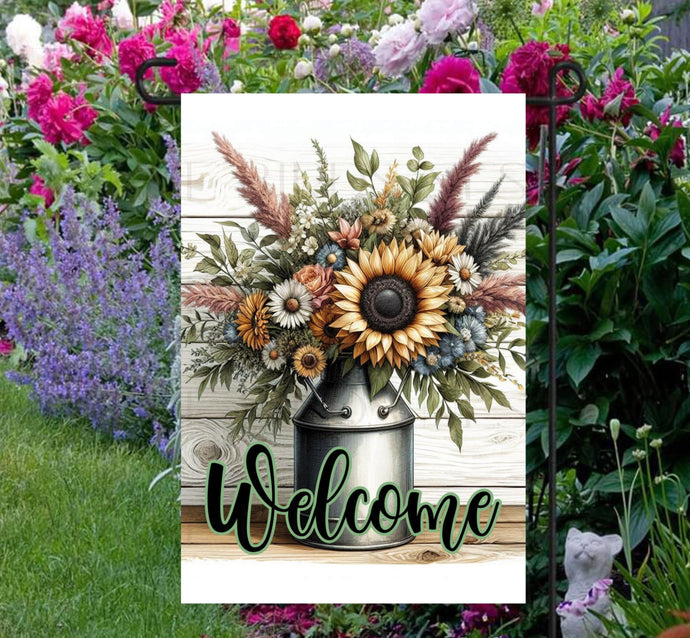 This beautiful double-sided Garden Flag features a rustic farmhouse scene with a metal milk can full of Sunflowers and other flowers with a Welcome message.