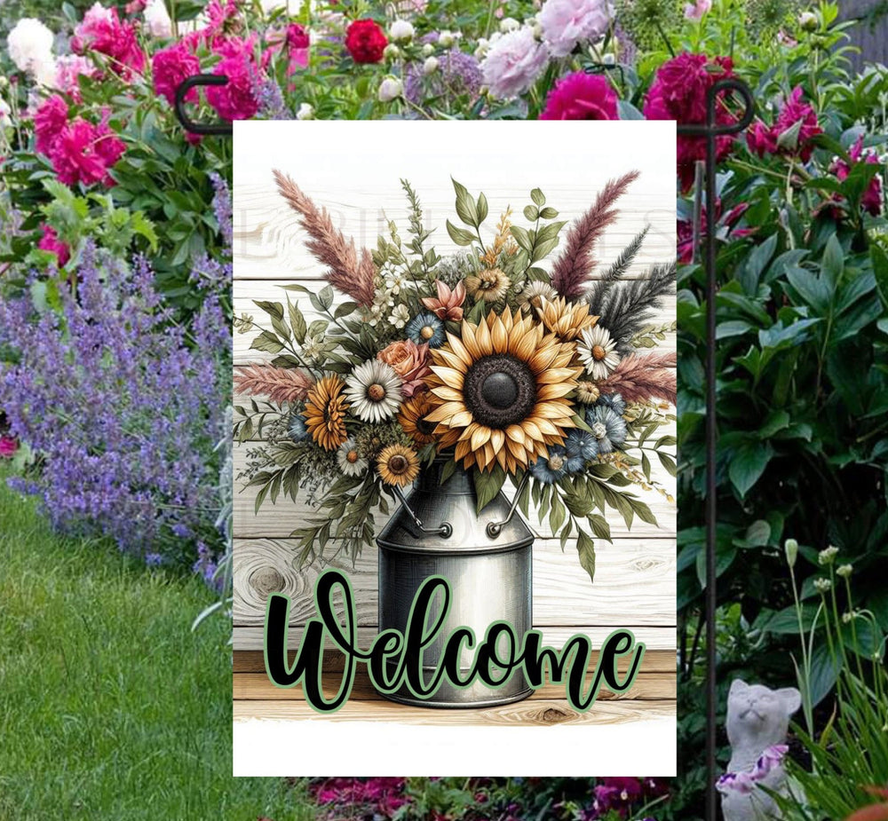 This beautiful double-sided Garden Flag features a rustic farmhouse scene with a metal milk can full of Sunflowers and other flowers with a Welcome message.