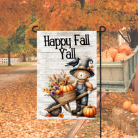 A beautiful Happy Fall Yall Garden Flag with a Scarecrow and his black Crow friend pushing a wheelbarrow filled with pumpkins and Fall flowers and foliage.