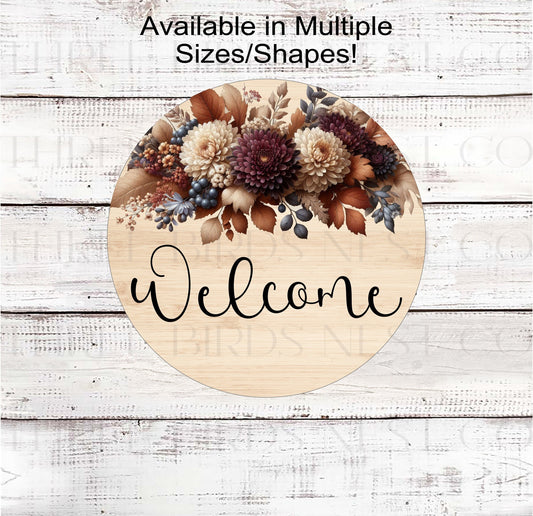 A beautiful Welcome Wreath Sign with Mums and Fall Florals on a rustic wood look background.