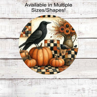 An adorable Primitive Wreath Sign featuring a black Crow sitting on a pumpkin, next to a vase of fresh apples with pip berries all around. Fall flowers on a background is a Fall colored quilt.