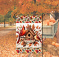 A beautiful Fall Welcome Garden Flag with a Male and Female Cardinal bird on a bird house with Fall leaves and acorns.