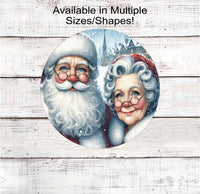 
              A beautiful Christmas Wreath Sign featuring a snowy pic of Santa and Mrs. Claus.
            