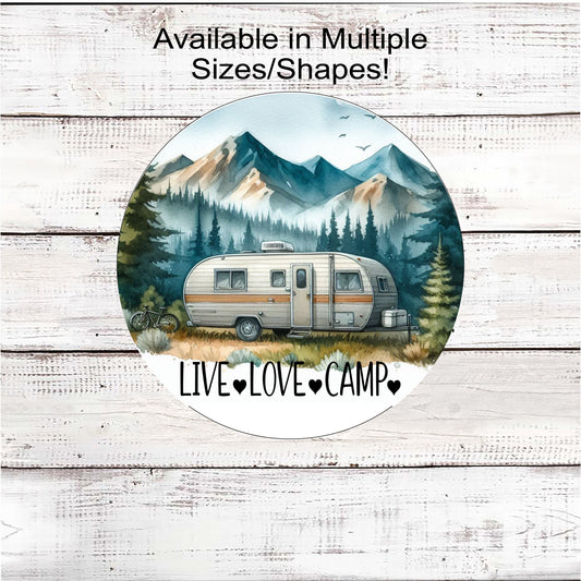 A beautiful Welcome Sign with a Camper in a beautiful mountain scene.