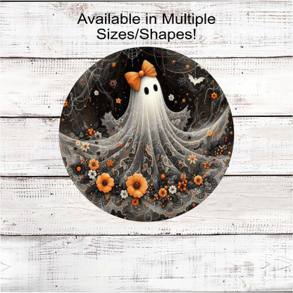 An adorable Halloween Ghost with an orange bow on her head and flowers around the bottom of her lacey sheet.