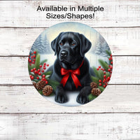 A black Labrador Retriever with in festive Winter setting and a red bow around his neck.