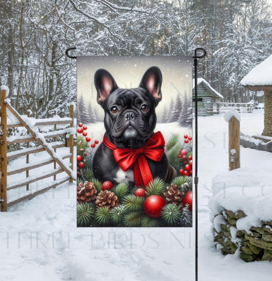 An adorable black French Bulldog in a snowy Winter setting wearing a red bow.