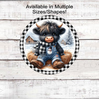 
              An adorable baby Scottish Highland Cow in his SNowman overalls and buffalo plaid scarf
            