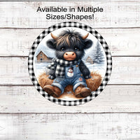 An adorable baby Scottish Highland Cow in his SNowman overalls and buffalo plaid scarf