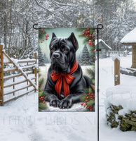 
              An adorable black Cane Corso Mastiff dog in a snowy Winter setting wearing a red bow.
            