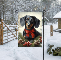 
              An adorable black Dachshund dog in a snowy Winter setting wearing a red bow.
            