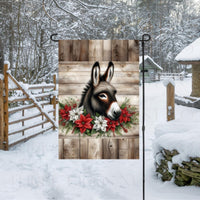 An adorable Donkey with a poinsettia swag on a rustic wood background.