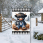 An adorable baby Highland Cow in his overalls with a Snowman