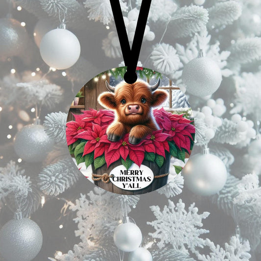 An adorable baby Highland Cow in a wooden tub surrounded by poinsettias.