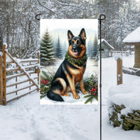 A black and tan German Sheherd dog in a Winter setting with a festive collar on.