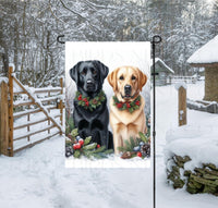 
              A black Labrador Retriever dog and a yellow Labrador Retriever dog in a Winter setting with festive collars on.
            