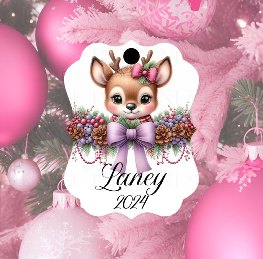 A girls ornament with a beautiful baby Deer with a purple bow and greenery with berries.