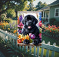 A beautiful black Newfoundland dog surrounded by gorgeous flowers.