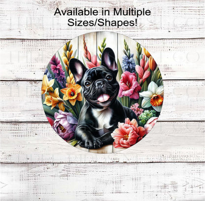 A beautiful black French Bulldog dog surrounded by bright Spring Flowers.