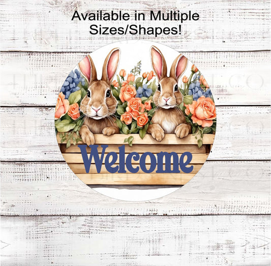 An adorable pair of Bunnies in a wood planter box surrounded by beautiful roses and hydrangeas.