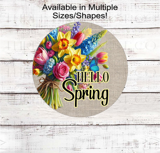 A beautiful bouquet of Spring Flowers and a Hello Spring message on a burlap background.