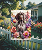 An adorable German Shorthaired Pointer Dog surrounded by Spring Flowers.