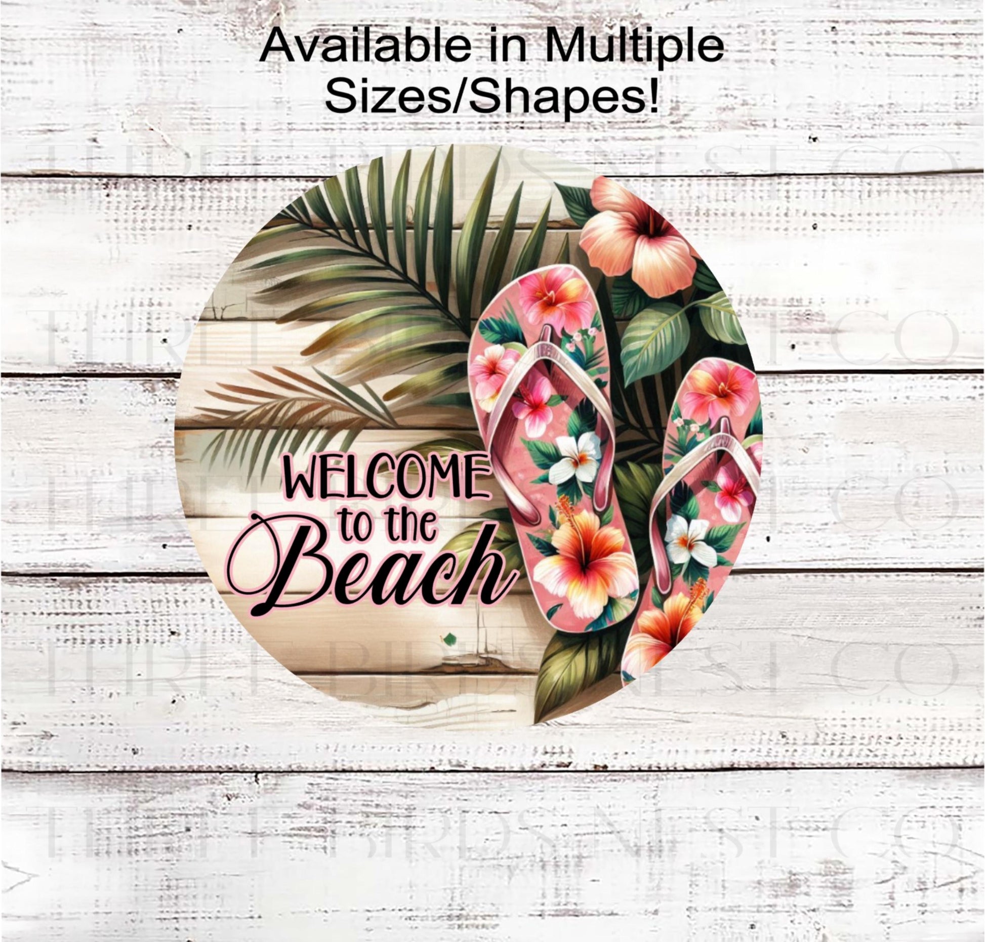 A beautiful Welcome to the Beach sign with palm leaves and hibiscus flowers.