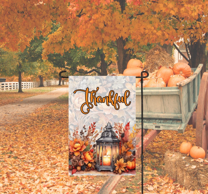 This beautiful Thankful Fall Garden Flag features a beautiful glowing lantern with candle that is surrounded by Fall flowers with a pumpkin