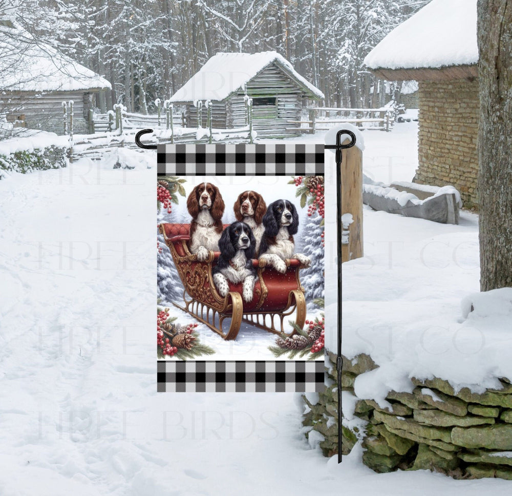 Four English Spring Spaniels sitting in a sleigh in a snowy Winter scene with greenery and berries collar.