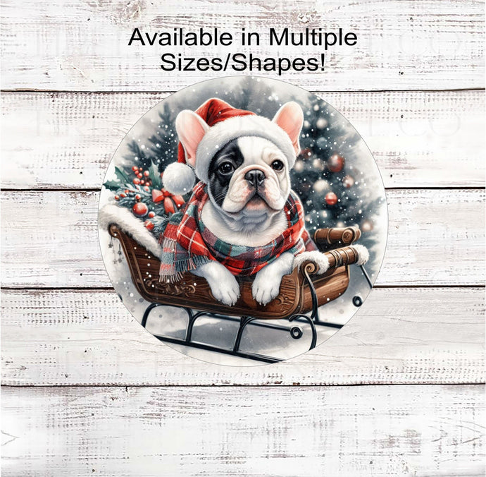 A black and white French Bulldog in a Santa hat and scarf with a Christmas tree and sleigh.