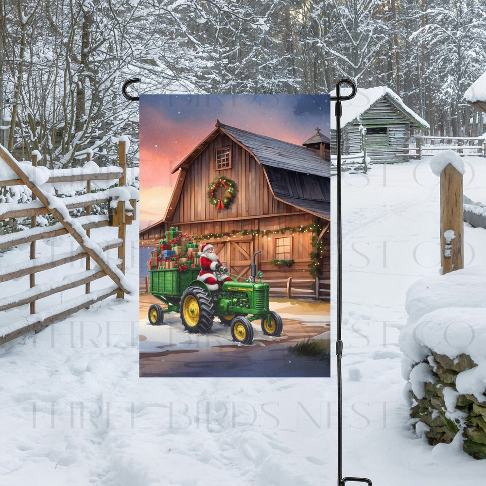 An adorable Garden Flag with Santa Claus on a farm tractor in front of a rustic Christmas Barn.