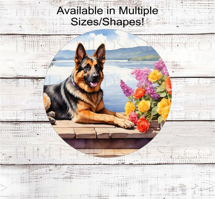 A beautiful German Shepherd dog on a dock with a flower pot overlooking a lake.