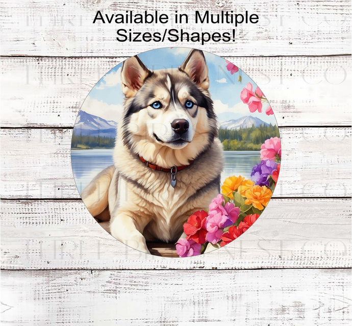 A black and white Siberian Husky Dog with blue eyes on a dock with a flower pot overlooking a lake.