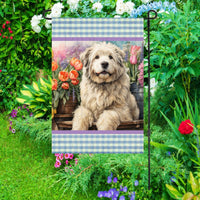 A beautiful Old English Sheep dog surrounded by gorgeous flowers.