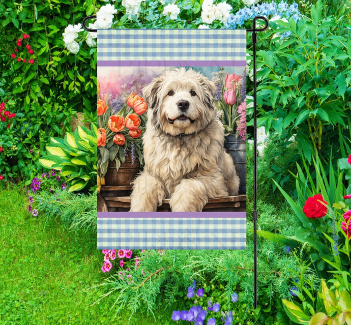 A beautiful Old English Sheep dog surrounded by gorgeous flowers.